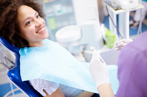 A smiling woman in dental office chair.