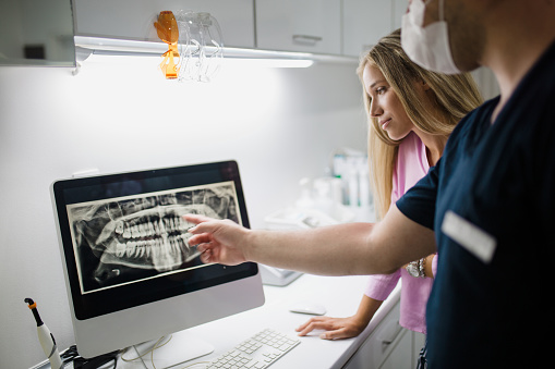 Dentist pointing at a digital x-ray.