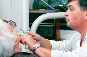 A dentist examing a mature patient during a dental exam at Christensen Family Dentistry.